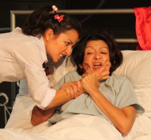 Girl Pinching womans cheeks scowling