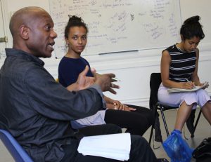 Actors reading from scripts in a circle