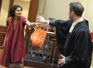 women actor pointing at barrister in courtroom