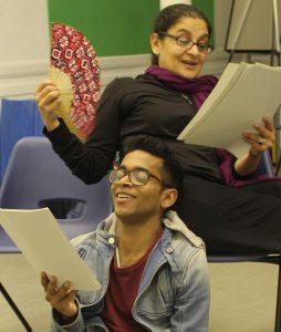 man and woman reading from script laughing