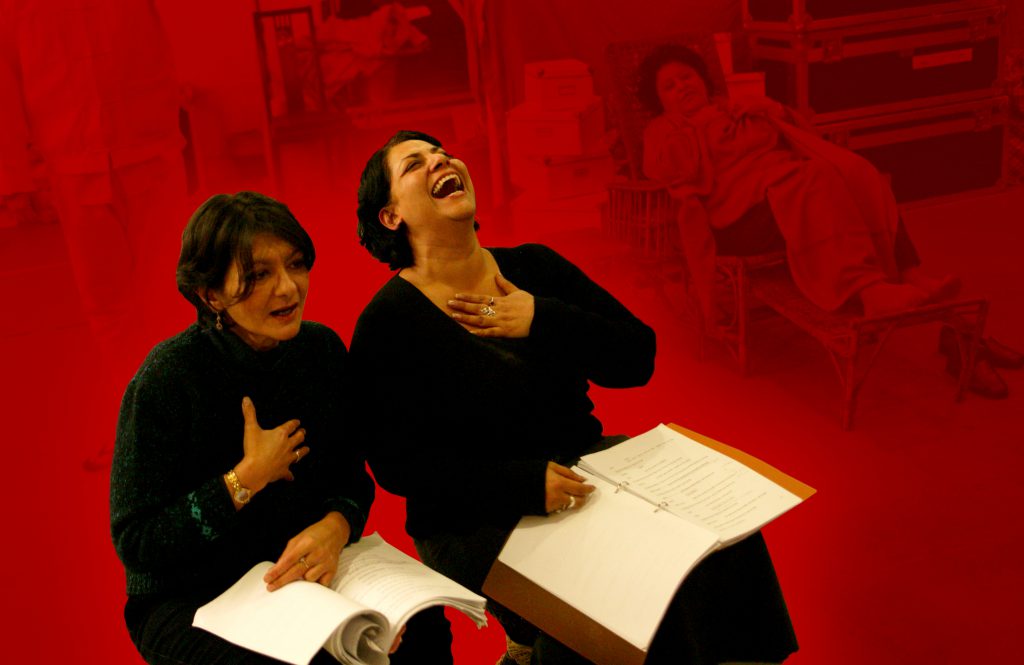 two women reading scripts laughing